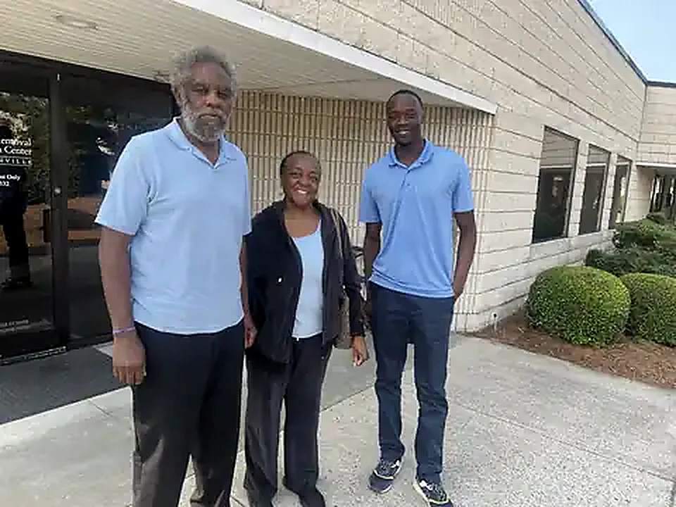 K Real Estate representative with local property owners outside a Greenville-area office