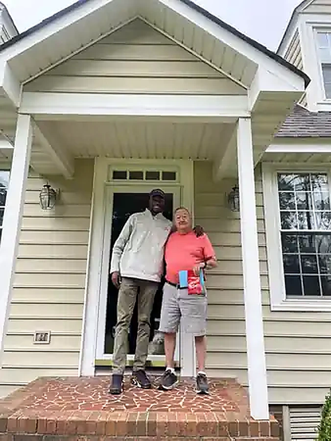 K Real Estate representative with a local property owner outside a home